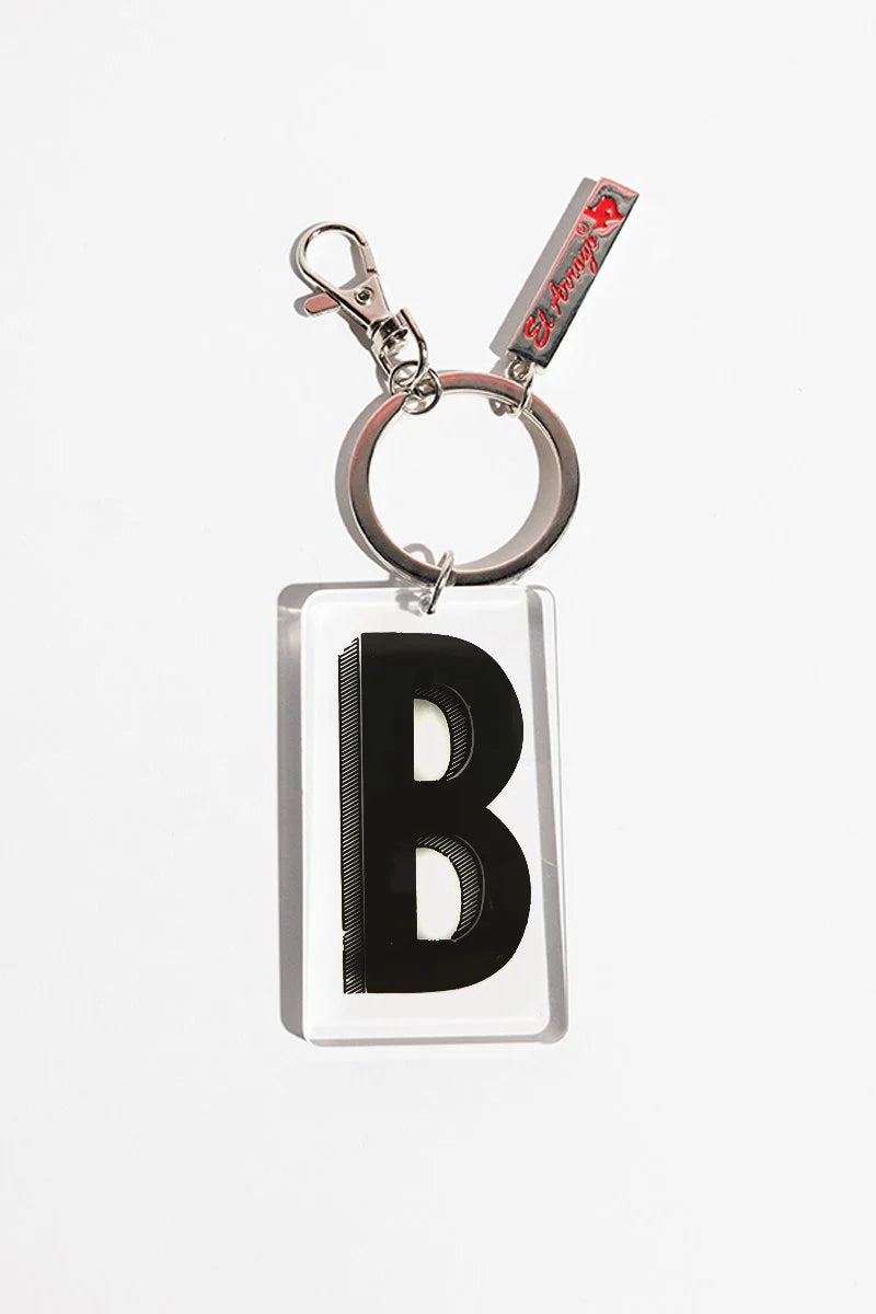 Clear acrylic keychain with bold black "B," silver keyring, clasp, and small El Arroyo tag. Available in one standard size.