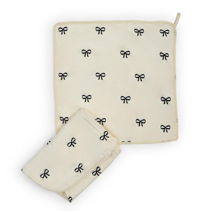 Cream Noir Coquette terry hair towel wrap with black bows, button closure, corner loop. Sizes: one size.