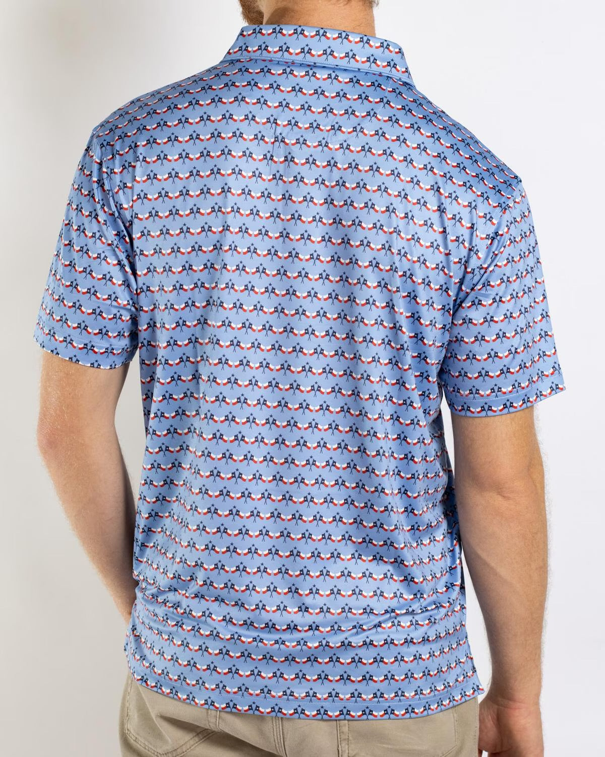 Men’s Texas Flag Performance Polo: light blue, short-sleeve, repeating penguin pattern. Available in sizes S–XXL.