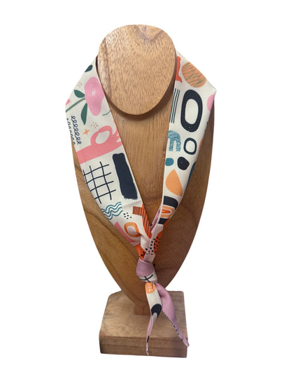 Scarf Necklace with abstract pink, black, orange, and teal shapes; available in small and large sizes; multi-functional accessory.