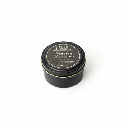 Black tin "Wickless Candle" with round lid, coconut soy wax, labeled "Roasted Pinecone," available in 5.75 oz size.
