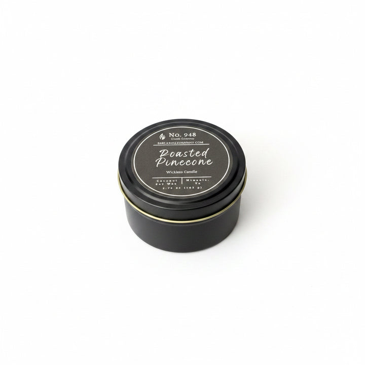 Black tin "Wickless Candle" with round lid, coconut soy wax, labeled "Roasted Pinecone," available in 5.75 oz size.