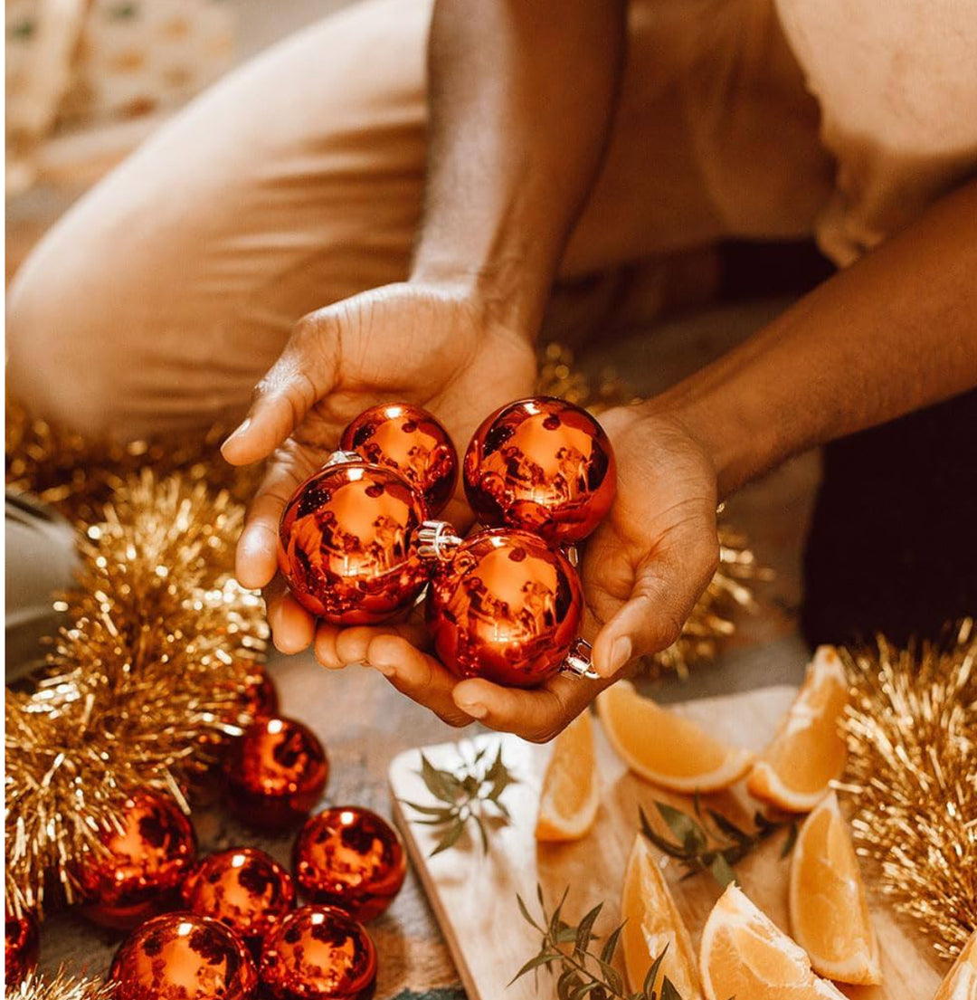 Four shiny orange ball ornaments.