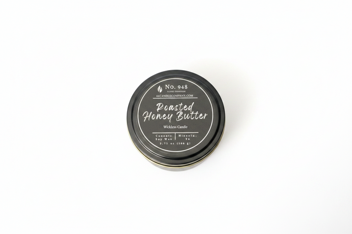 Small round tin labeled "Roasted Honey Butter" Wickless Candle, 5.75 oz size, No. 948, made from coconut soy wax with a black lid featuring white decorative text and product details.