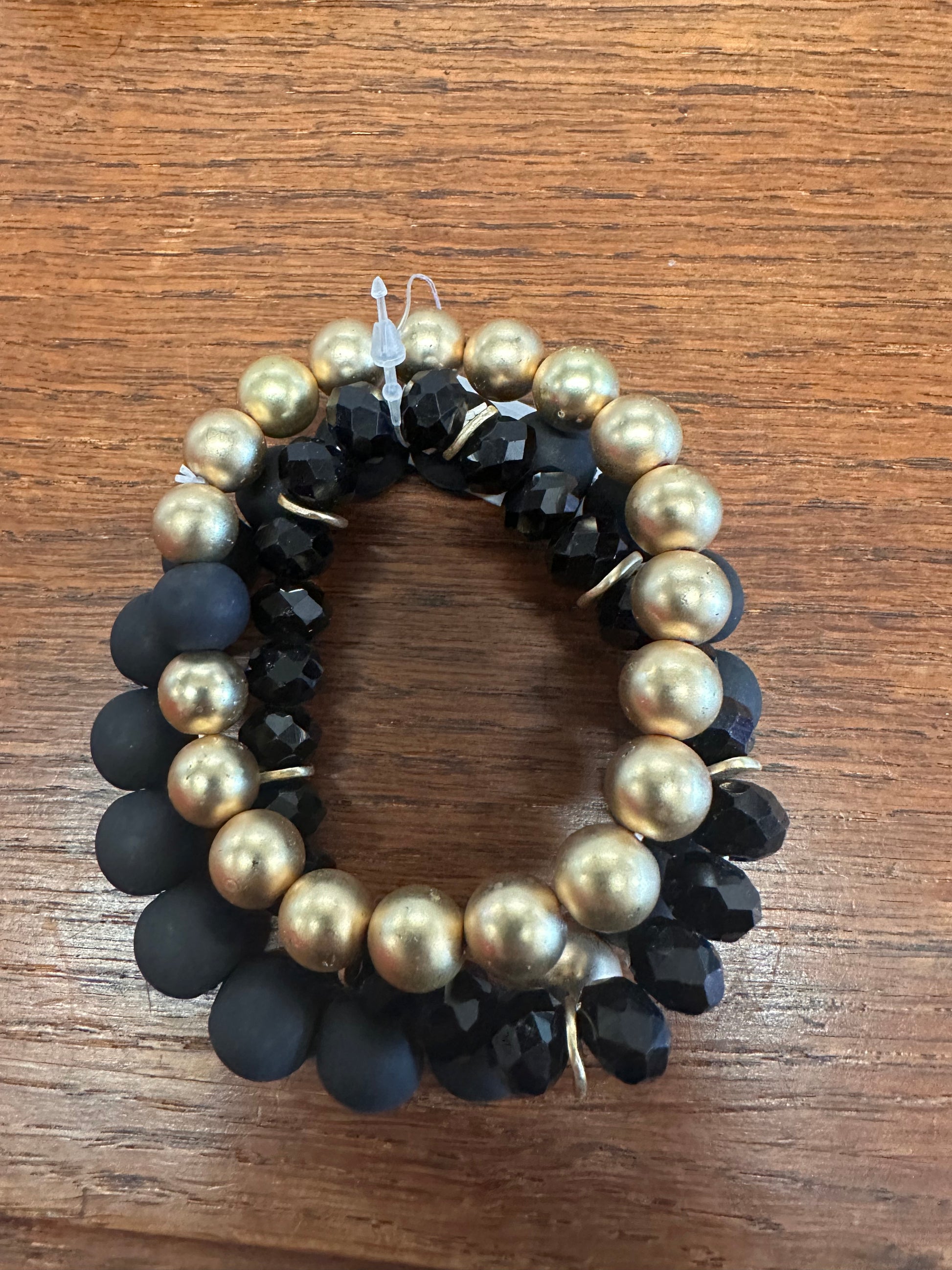 This is a wreath-shaped bracelet made of 12MM clay balls. The bracelet features a pattern of alternating black matte beads and glossy golden beads. It's designed to deliver a sophisticated yet playful aesthetic.