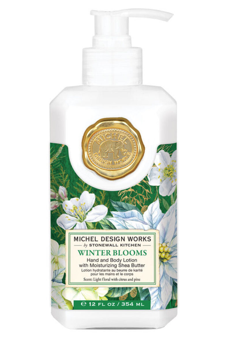 A 12 fl oz bottle of Winter Blooms Hand and Body Lotion by Michel Design Works, featuring a pump dispenser. The label showcases illustrations of white flowers and green leaves, complemented by a gold seal. Infused with botanical ingredients and moisturizing shea butter. Light floral scent adds festive cheer. Sizes available: 12 fl oz only.