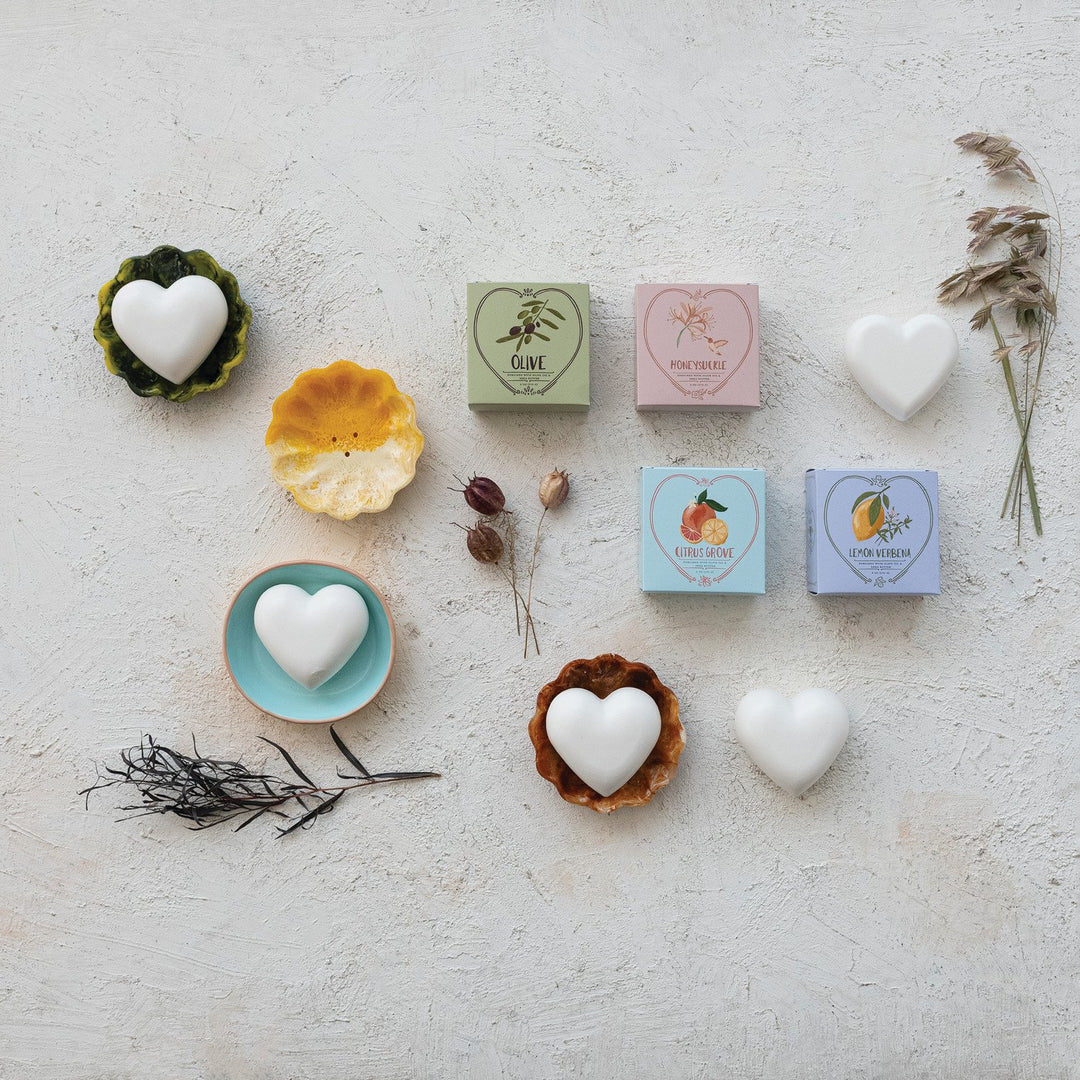 Four heart-shaped triple-milled shea butter soaps, available in Olive, Rose Peche, Lemon Grass, and Citron Verbena scents.