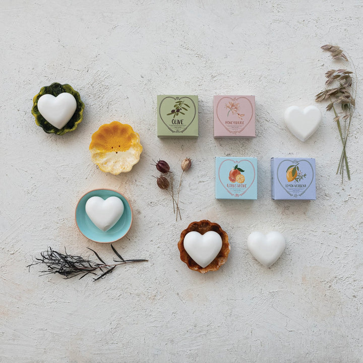 Four heart-shaped triple-milled shea butter soaps, available in Olive, Rose Peche, Lemon Grass, and Citron Verbena scents.