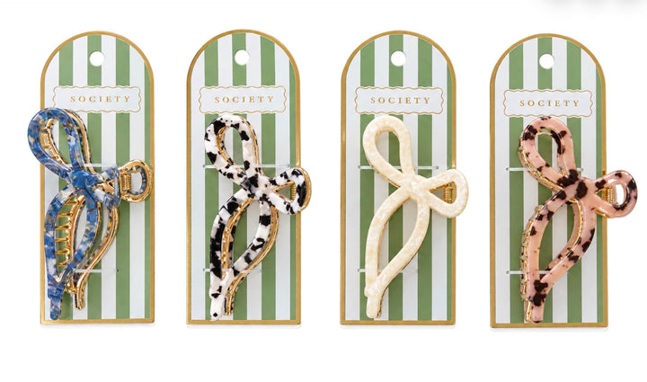 Set of four patterned Metal Bow Claw Clips in blue, black and white, cream, and pink tortoiseshell designs. Available in small and medium sizes.