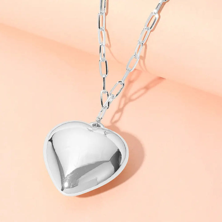 The Metal Puffy Heart Pendant Paperclip Chain Necklace features a gleaming silver heart-shaped charm. Available in one size.