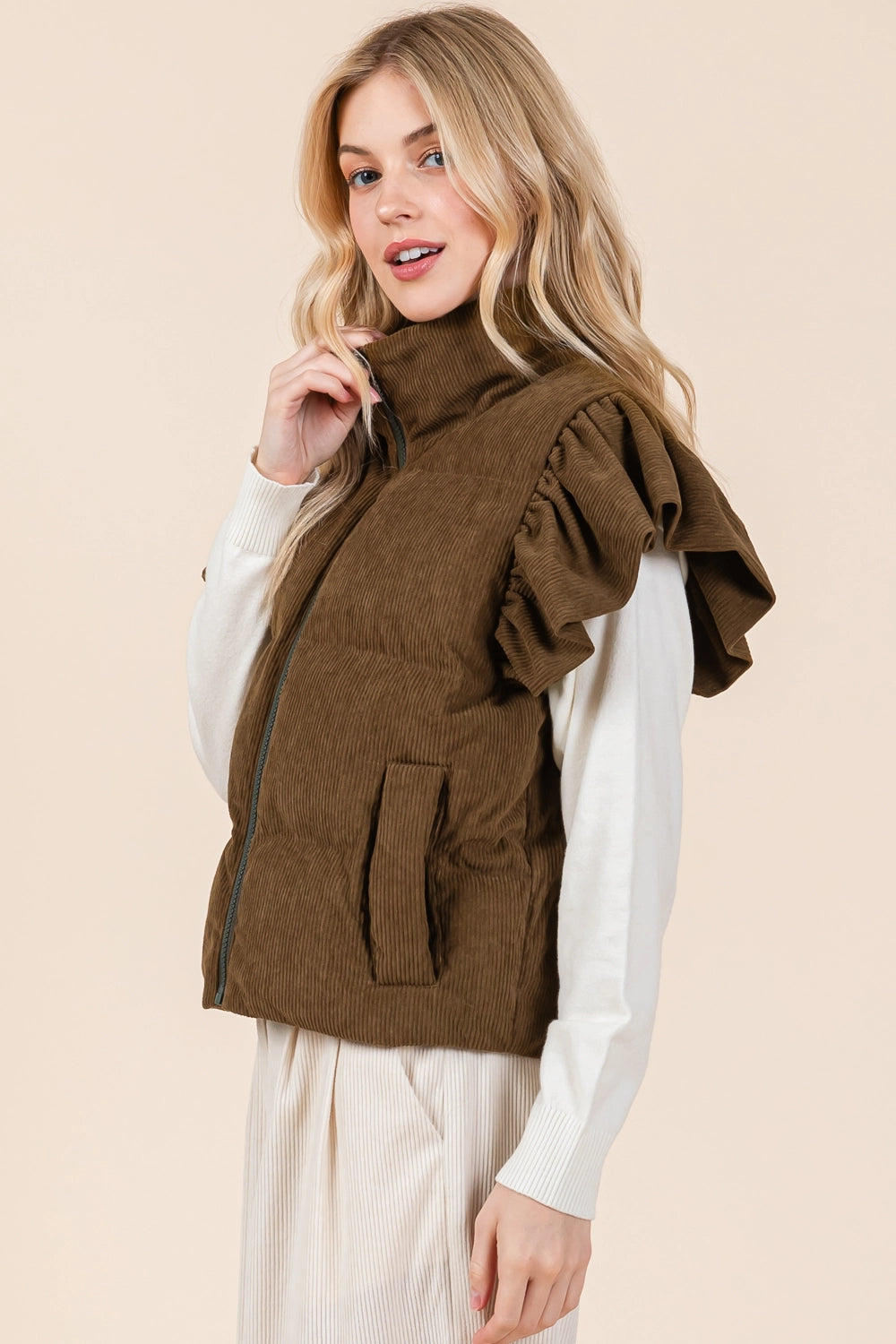 The Puff & Ruffle Corduroy Vest is a stylish brown vest with ruffle sleeve detailing, ideal for fall and winter wear. Available sizes: XS, S, M, L, XL.