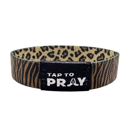Safari Leopard Tap To Pray™ wristband, brown/black leopard print, black patch, white text/praying hands. Sizes: S/M, L/XL.