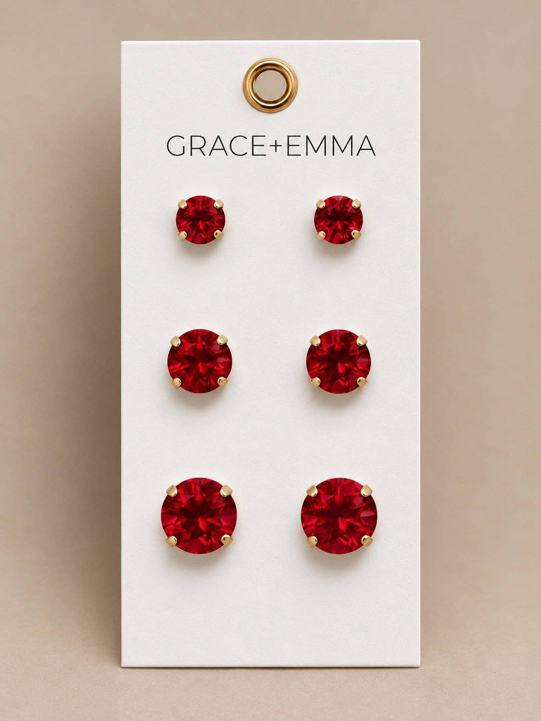 Three pairs of red stud earrings with graduated stones.