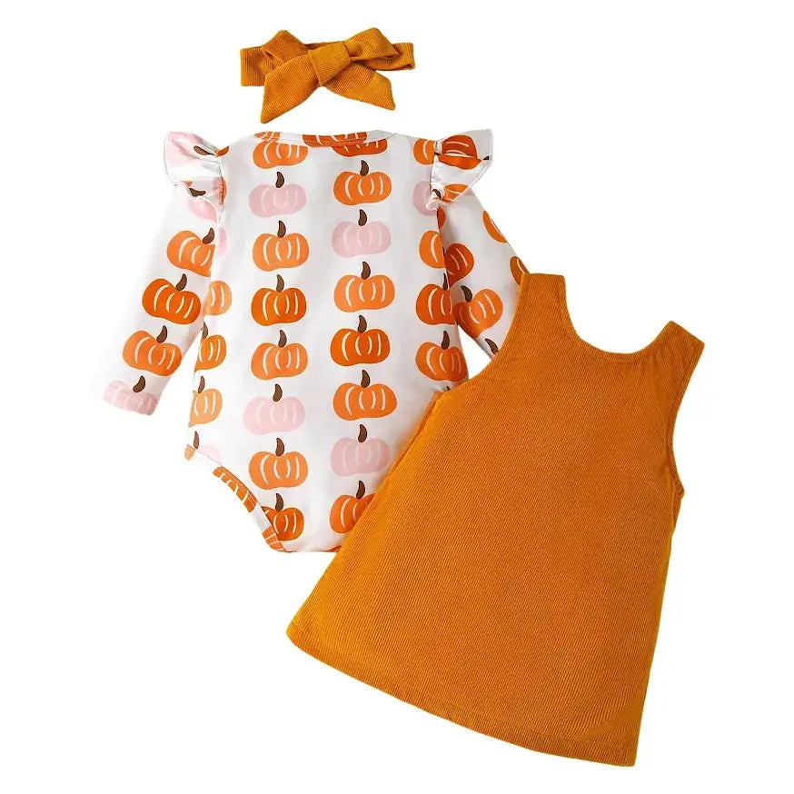 Pumpkin Harvest 3-Piece Baby Dress Outfit includes a pumpkin-print long-sleeve onesie with ruffled shoulders, a mustard yellow sleeveless dress, and a matching bow headband. Available in sizes 0-18 months.