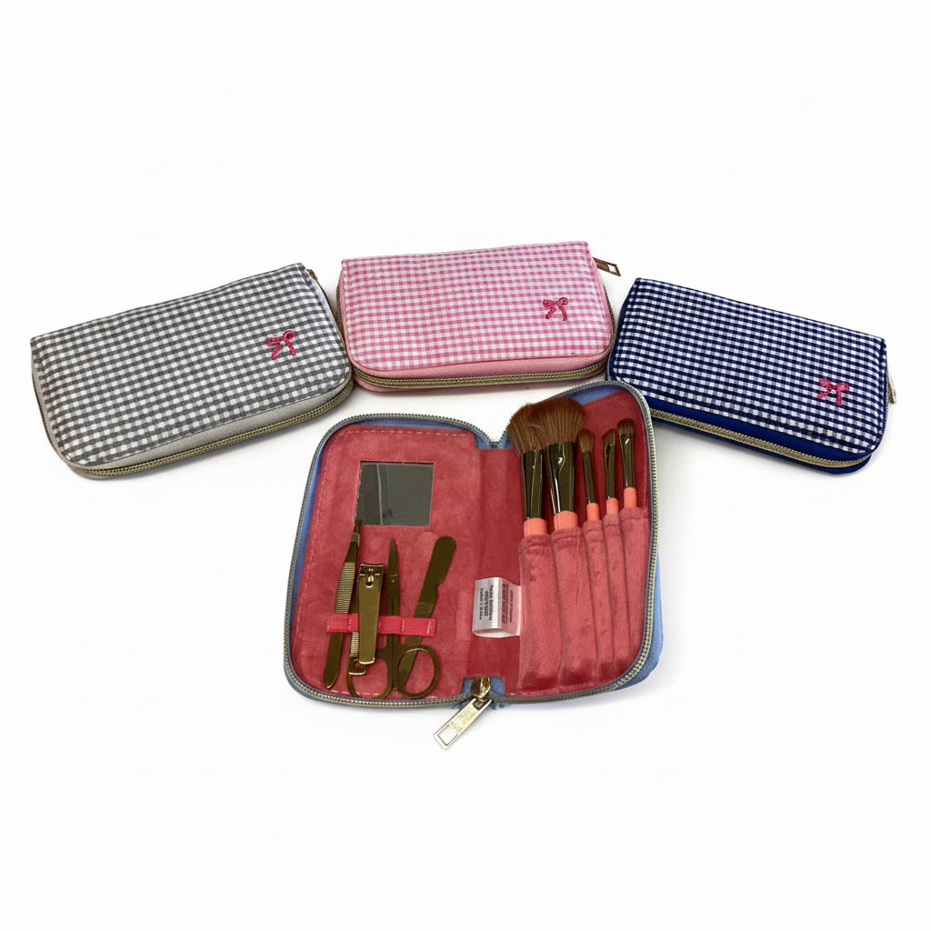Gingham Travel Cosmetic Kit: three zip-up pouches in gray, pink, and blue; includes brushes and tools. Sizes: small, medium, large.