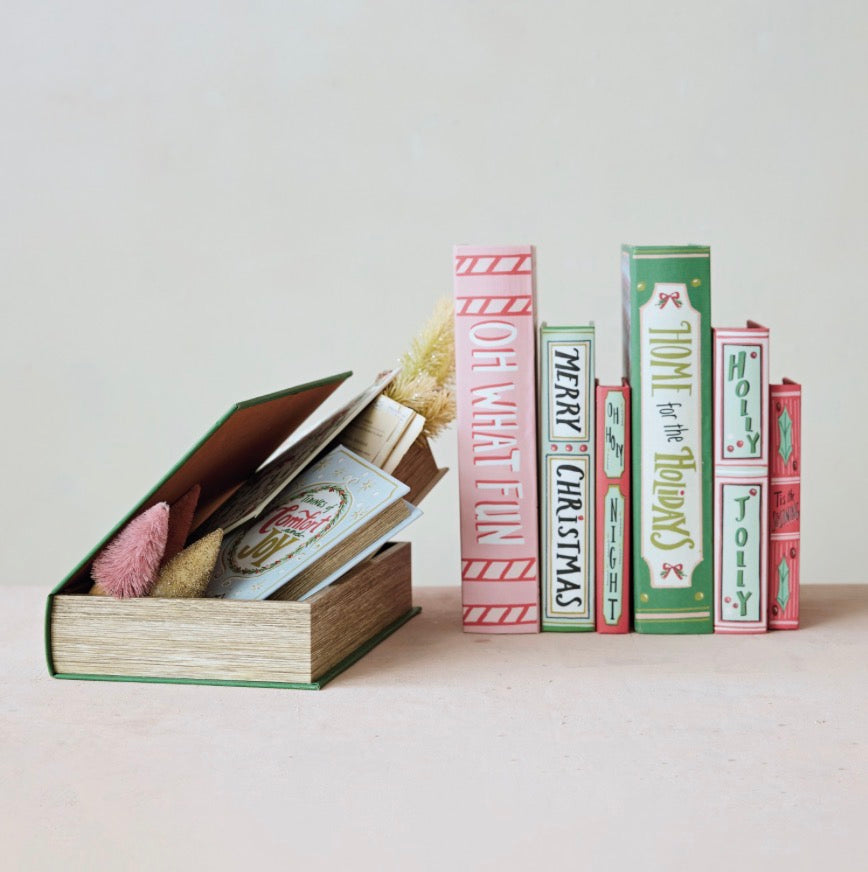 Five holiday-themed canvas book storage boxes standing upright and one open, multicolor canvas box lying flat.