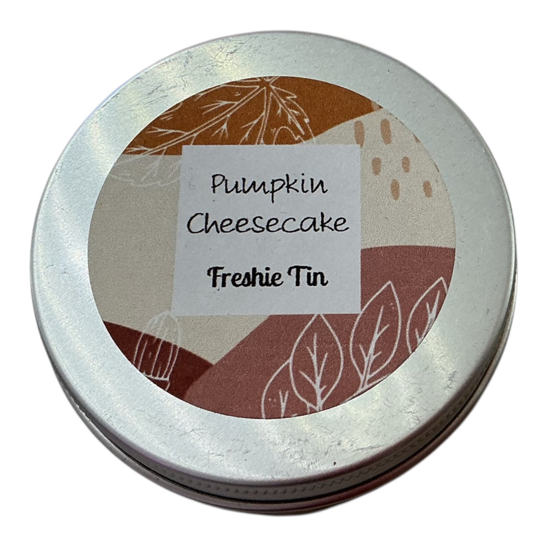 Round Freshie Tin labeled "Pumpkin Cheesecake" with fall leaves and dots pattern; available in 4oz and 8oz sizes.