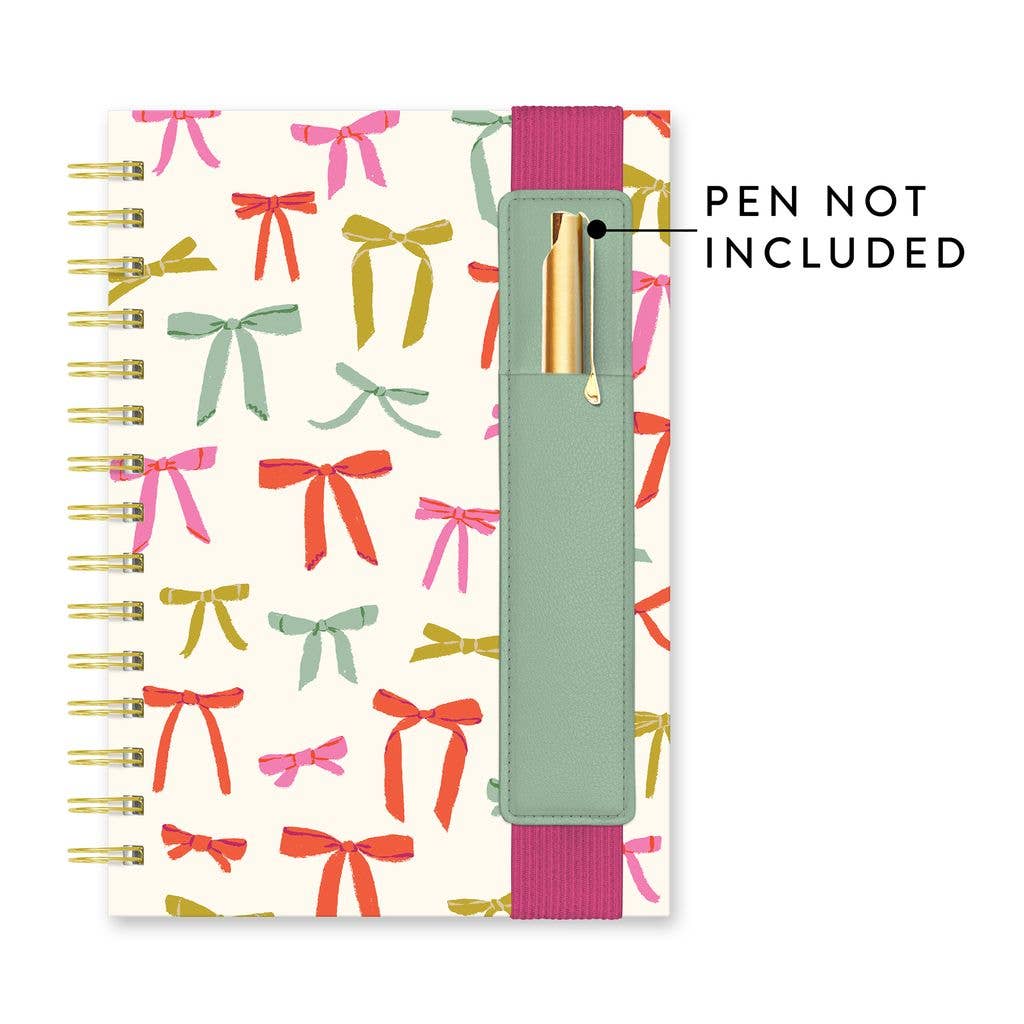 Spiral Put a Bow on It Oliver Notebook, colorful bows, vegan leather pen pocket with pink elastic. Sizes: not specified.