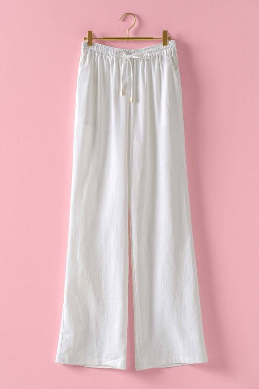 White linen blend wide leg drawstring pants with elastic waistband and relaxed fit; available in sizes XS-XL.