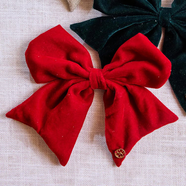 Red and dark green holiday magnetic bows in 4 styles with a metallic logo charm.
