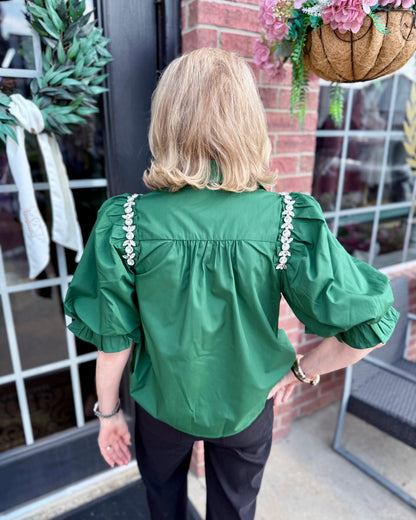 Hadley Blouse in hunter green with embellished shoulder details and subtle puff sleeves, available in sizes XS-XL.