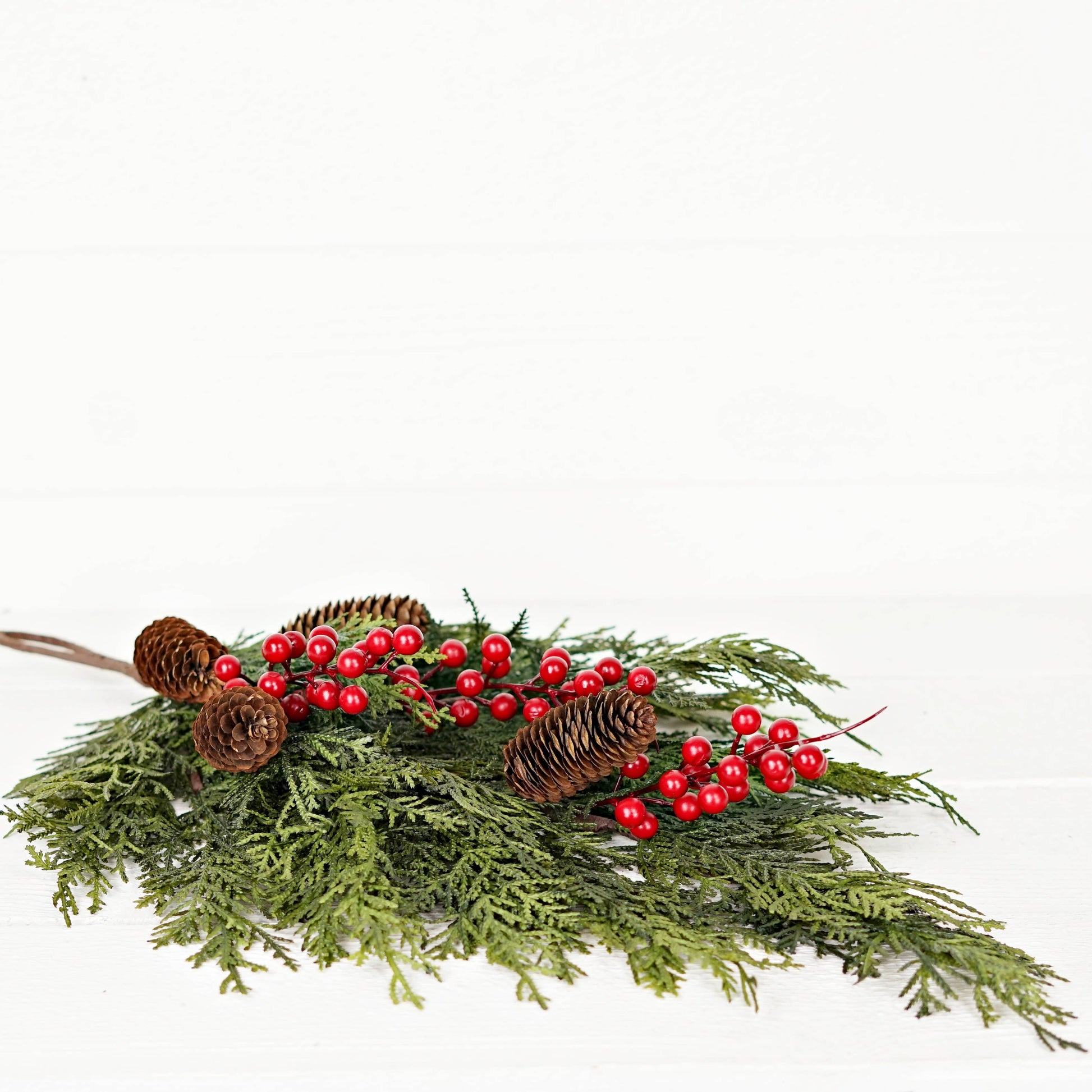 510053 Teardrop arrangement, 26inL x 16inW, made with real touch mixed cedar, red berries, and pine cones.