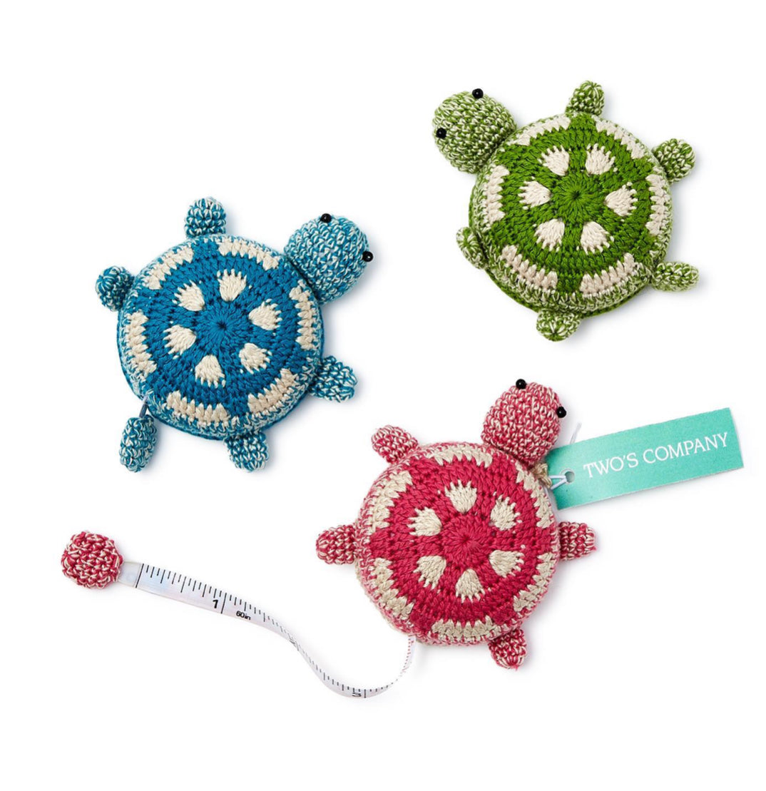 This crocheted knit measuring tape is shaped like a turtle. It comes in three colors green turquoise and pink measures up to 60 inches.