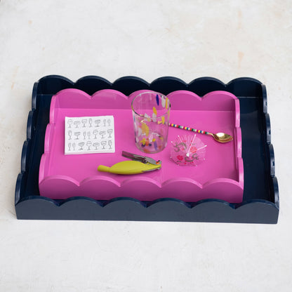 Navy lacquered scalloped tray with handles, available in multiple sizes. Pink scalloped tray nested inside.