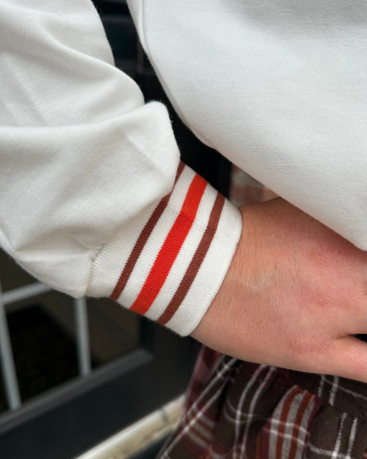 Pumpkin Patch Long Sleeve Top with brown and red striped cuff. Available in sizes XS–XL.