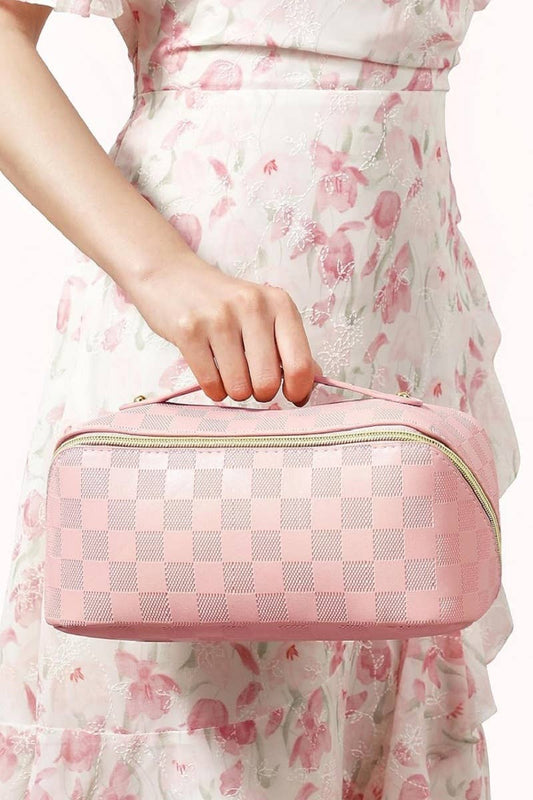 Pink vegan leather checkered flat-lay makeup bag with zippered pouch and handle. Available in small, medium, and large sizes.