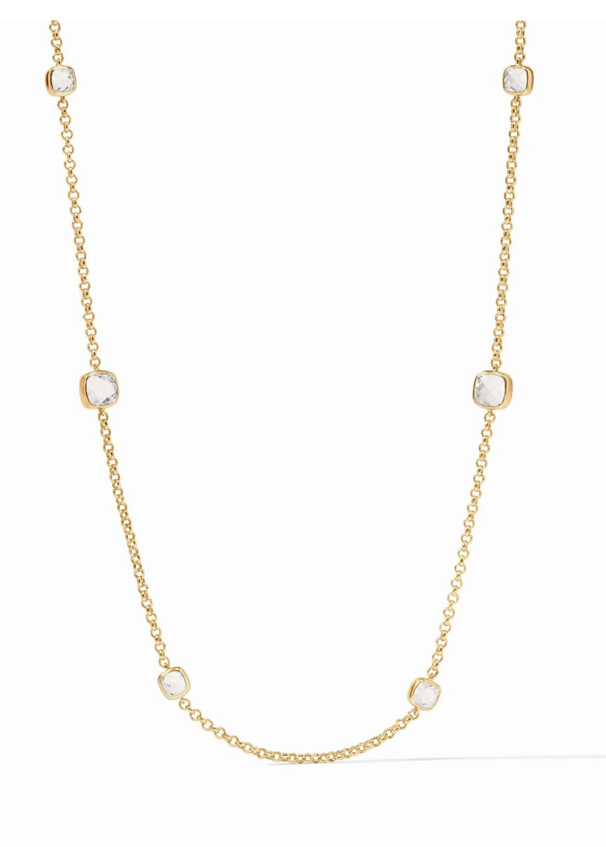 The Aquitaine Station Necklace is a chic accessory featuring varying sizes of glittering clear crystals, all bezel-set and evenly spaced. The necklace is luxuriously made from gold to add sparkle to any attire. Preferably showcased against a white background for aesthetic appeal. This product comes in one standard size.