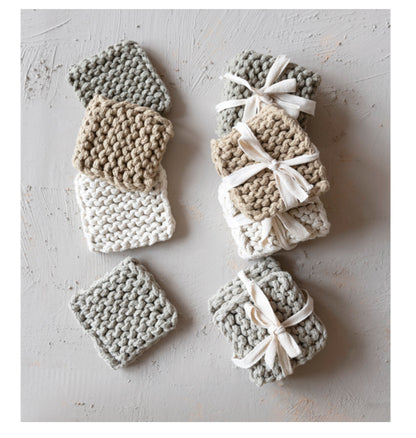 Set of four 100% cotton crocheted coasters in grey, white, and beige. Sizes: 4-inch diameter.