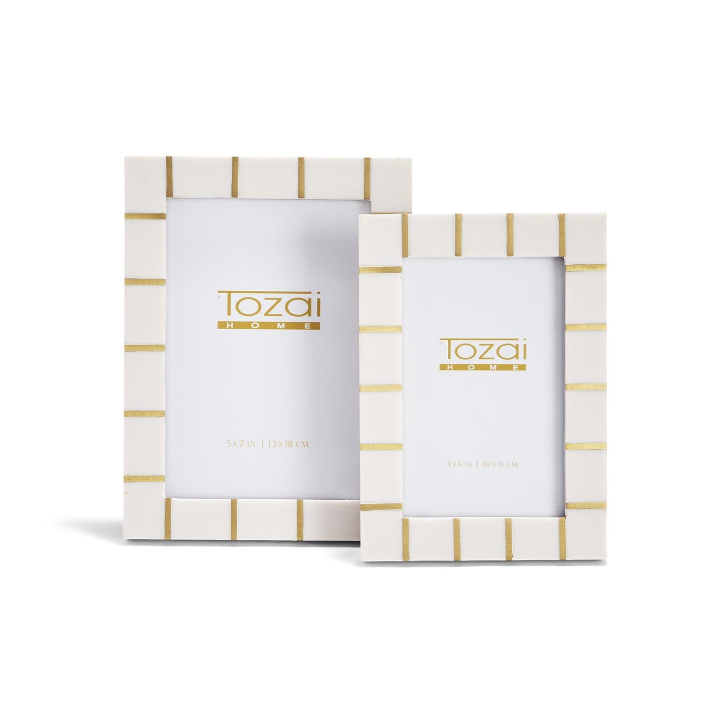 White rectangular resin photo frames with gold horizontal stripes from the Brass Lines collection, available in two sizes. Each frame displays the "Tozai Home" logo and frame dimensions.