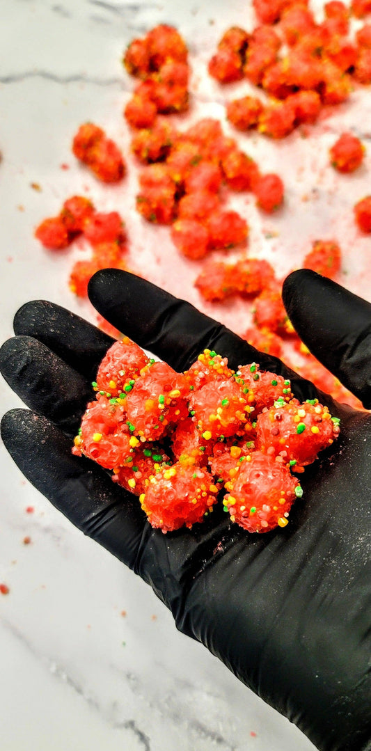 Bright red, round Original Crunchy Clusters: Singles, coated in colorful sprinkles. Available in small and large sizes.