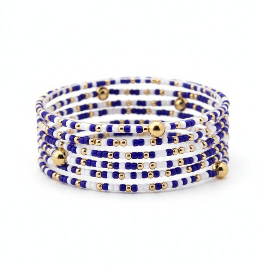 The Mira Kentucky Blue Gold Accent Stretch Bracelet Stack features a coiled design with small blue, white, and gold beads and scattered larger gold beads. Available sizes: S/M, M/L.
