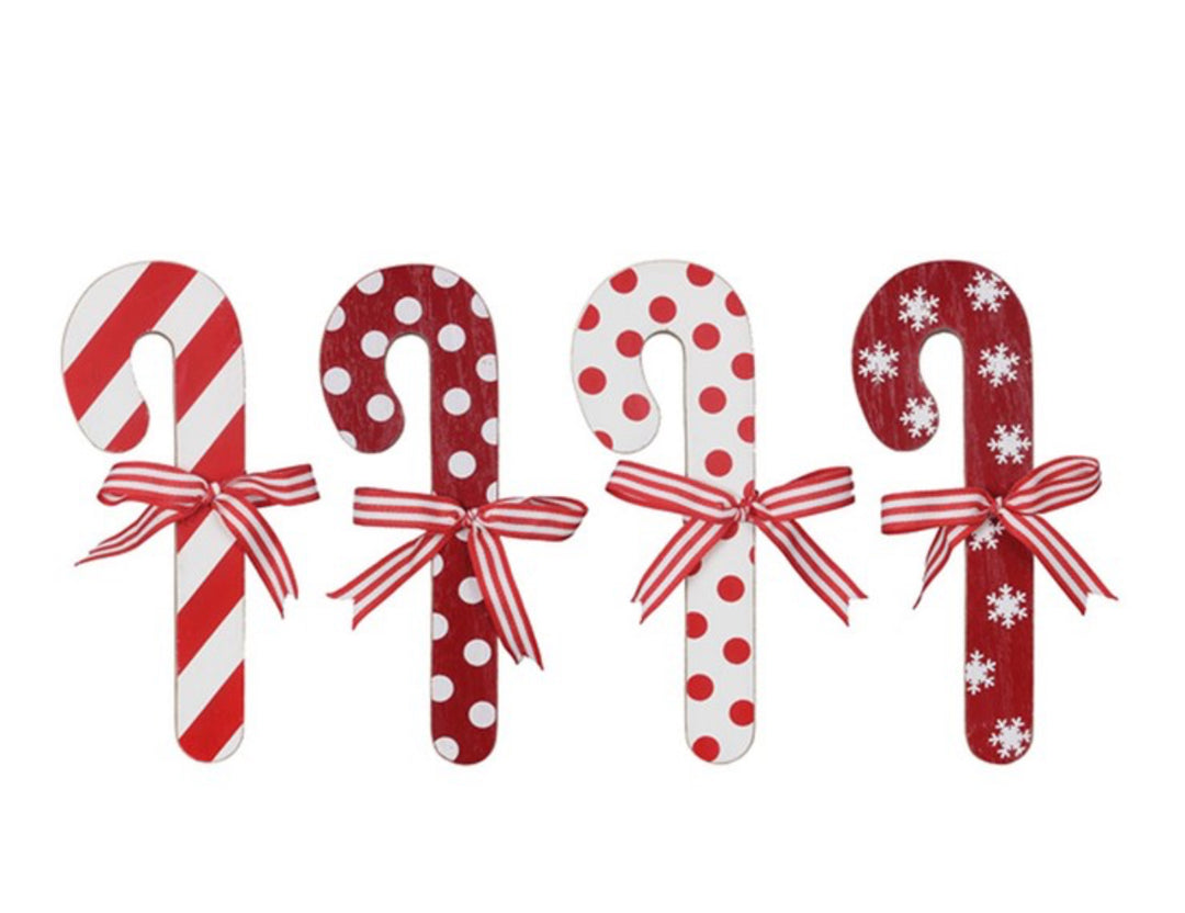 Wood Cocoa and Cookies Candy Cane Wall Decor: four wooden ornaments with striped bows featuring red stripes, red polka dots, white polka dots, and white snowflakes.