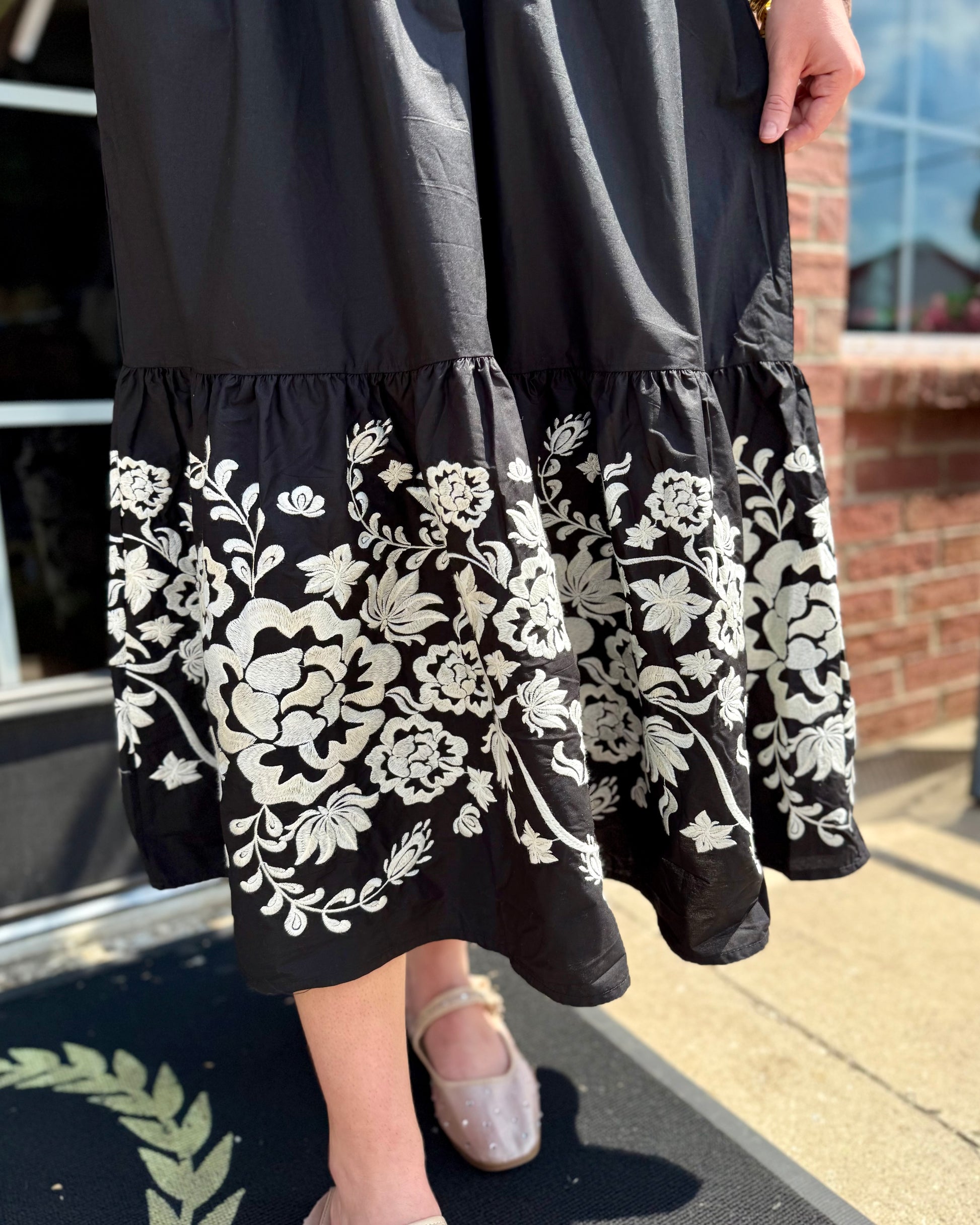Tracey Aven Vines Black Dress with white floral embroidery and smocked waist; available in sizes XS–XL.