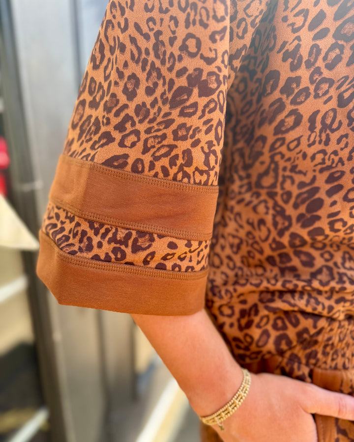 Leopard Zip-Up Top with leopard print, sheer striped sleeves, and faux suede fabric. Available in sizes S-XL.