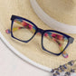 The Peepers - Maisie glasses: bold dark square frames, colorful temples. Available in small, medium, and large sizes.