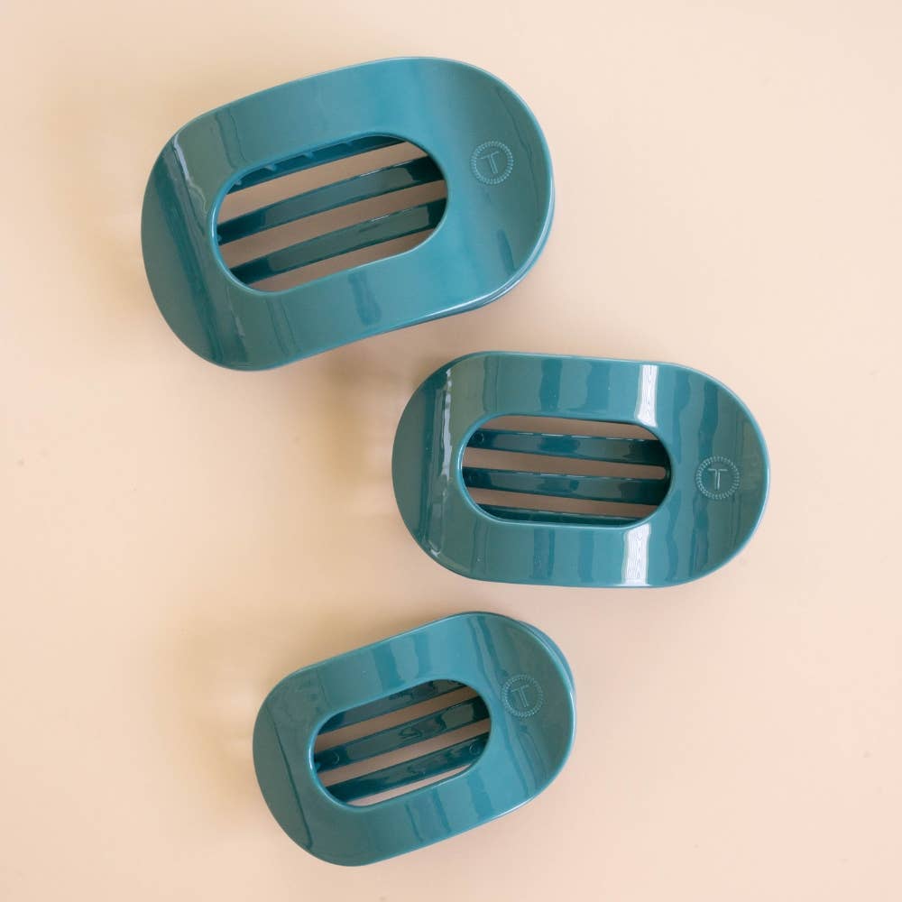 Three teal oval-shaped soap dishes with slotted centers, available in multiple sizes.