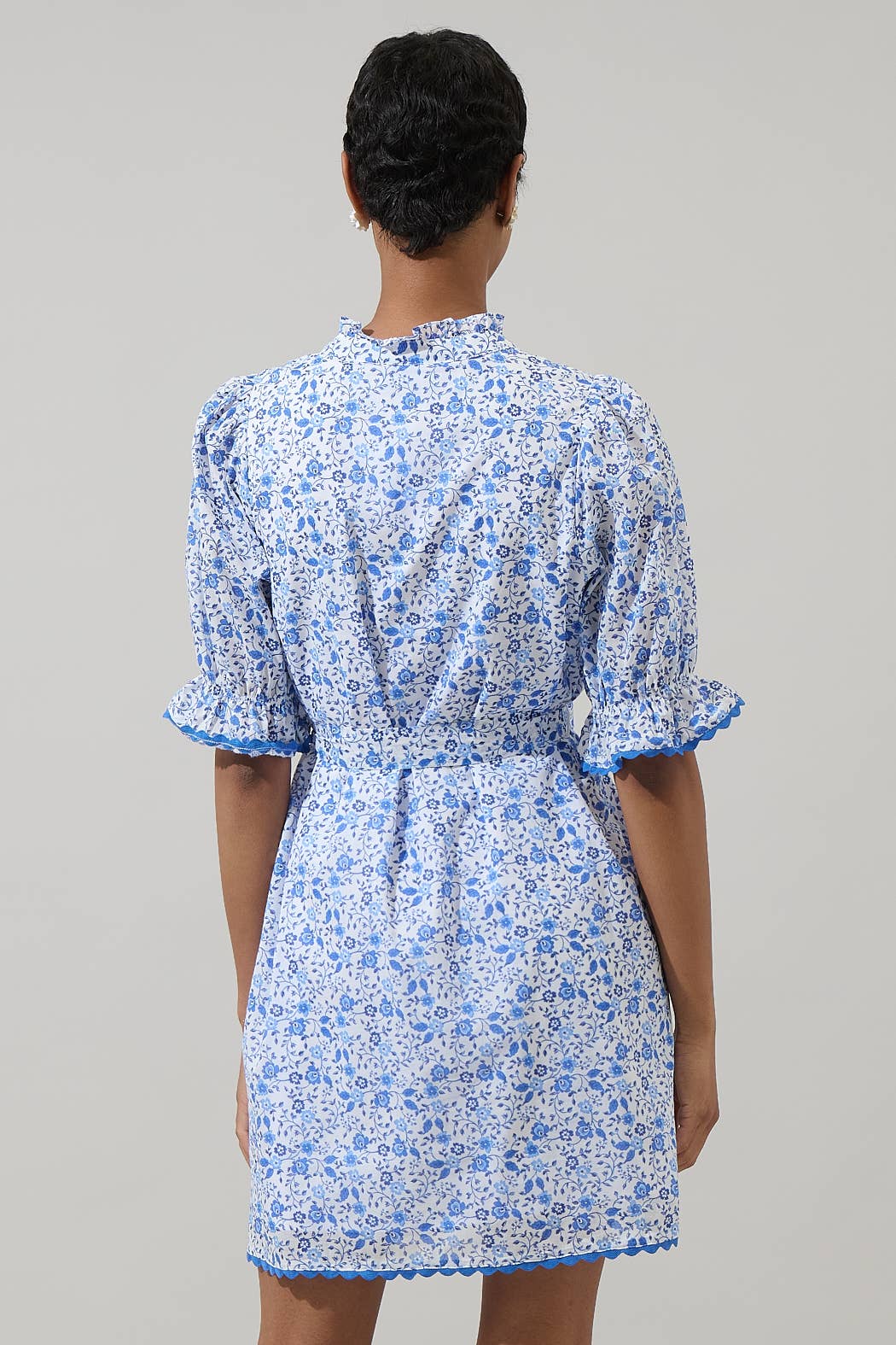 Maisie Floral Miana Button Up Dress with white and blue florals, puffed sleeves, ruffled cuffs. Available in sizes XS-XL.