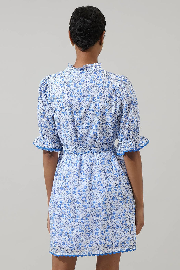 Maisie Floral Miana Button Up Dress with white and blue florals, puffed sleeves, ruffled cuffs. Available in sizes XS-XL.