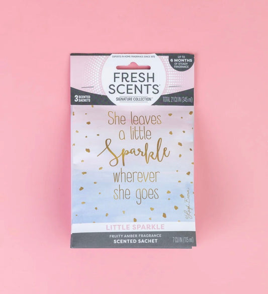 The Little Sparkle Scented Sachet features the phrases “She leaves a little sparkle wherever she goes” and “Little Sparkle, fruity amber fragrance.” This flameless sachet provides a long-lasting home fragrance. Sizes available: [sizes not specified].