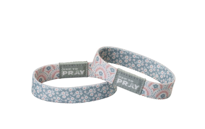 Two blue and pink floral-patterned Tap To Pray™ Wristbands - Boho with gray “Tap To Pray” tags.