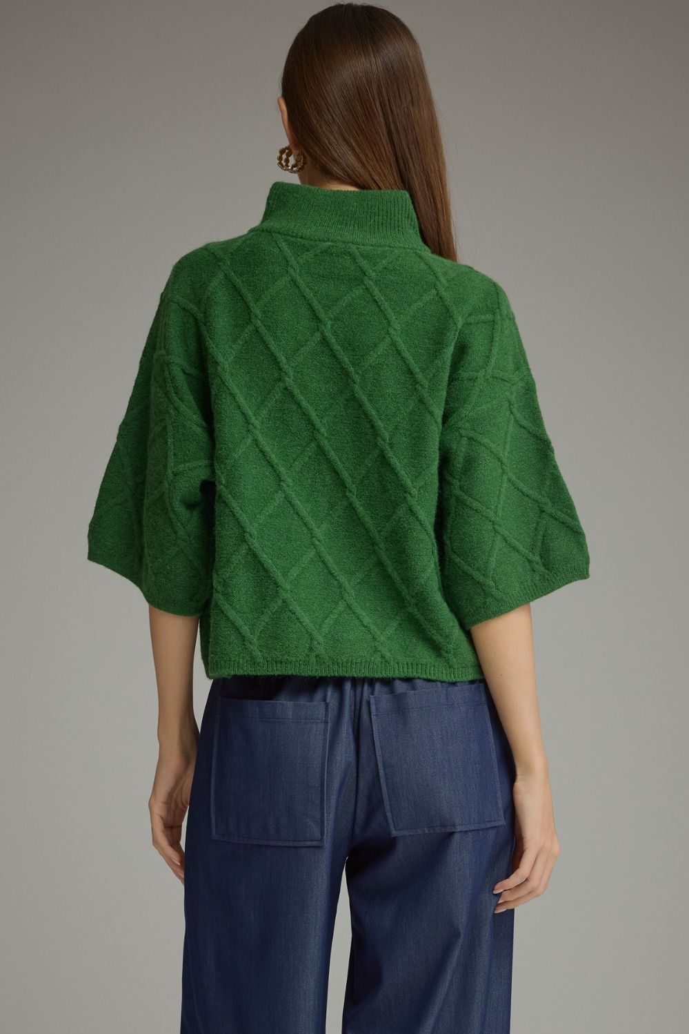 Green diamond textured sweater with high stand collar, elbow-length sleeves, and cropped hem.