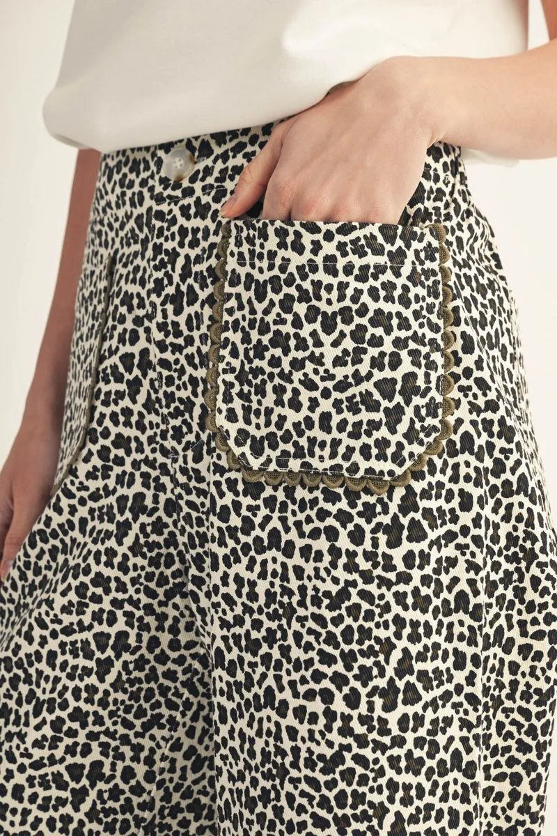 Animal print jeans with olive green scalloped pocket trim.
