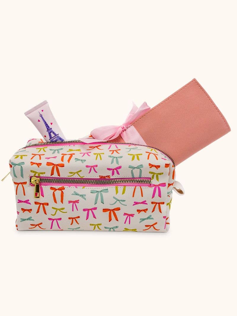 The Put a Bow on It Loaf Cosmetic Pouch is white vegan leather with colorful bows, gold zipper, front pocket. Sizes: S/M/L.