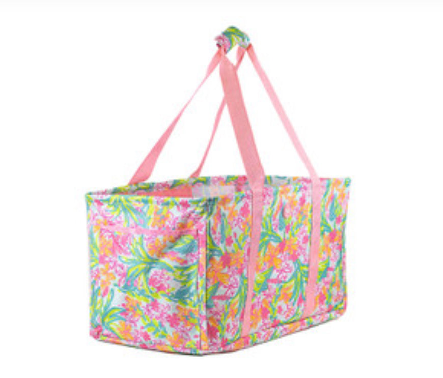 This tote measures 22 x 12 x 12 it’s a Grenada collapsible tote so it can collapse down to just the measurements. It is flowers. It has orange green teal hot pink and it has straps that run along the side. It is shaped as a rectangle.