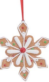 Snowflake gingerbread ornament with white icing, red and green accents, and a red hanging ribbon.