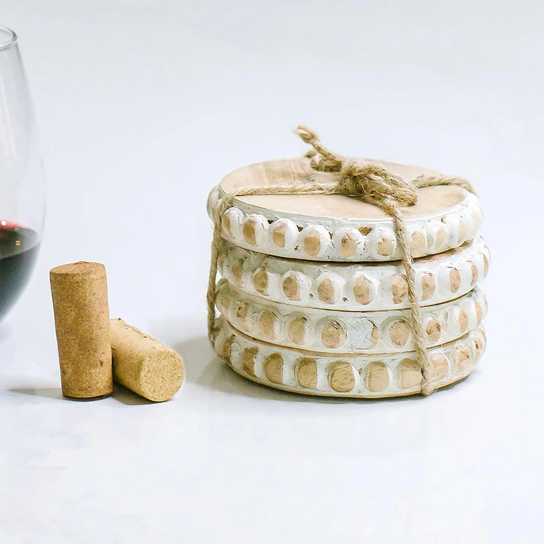 Stack of round, decorative wood coasters tied with twine. Available sizes: 4", 4.5", and 5" diameter.